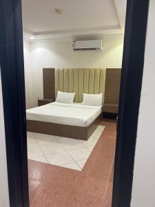 um quarto com uma cama com lençóis brancos e almofadas em ديم نجد للشقق المفروشة em Riade