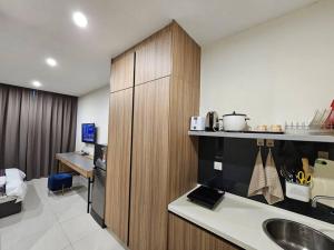 een keuken met een wastafel en een bureau in een kamer bij Kozi Square comfort Studio Home 3E in Kuching