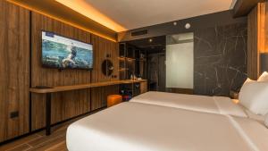sypialnia z łóżkiem i telewizorem na ścianie w obiekcie AX ODYCY Hotel w mieście St Paul's Bay