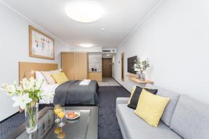 a hotel room with a bed and a couch at Rent like home - Apartamenty DEO PLAZA in Gdańsk