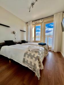 sypialnia z dużym łóżkiem i dużym oknem w obiekcie Moderno apartamento inteligente w Madrycie