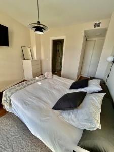 sypialnia z dużym białym łóżkiem z poduszkami w obiekcie Moderno apartamento inteligente w Madrycie