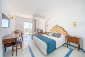 a bedroom with a bed and a desk and a table at Hotel San Francesco in Maiori