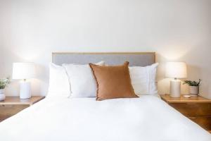 1 cama blanca grande con almohadas y 2 lámparas en Byron's Beach House Mylestom, en Mylestom