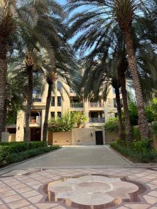 a building with palm trees in front of a courtyard at SmartApt Elegant 1 BDR Burj view in Dubai