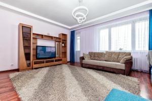 a living room with a couch and a television at Апартаменты 2day apart у Байтерека in Astana