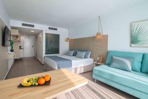 Habitación de hotel con cama y mesa con fruta en MarSenses Rosa del Mar Hotel & Spa en Palmanova