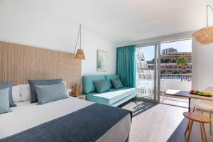 a hotel room with a bed and a balcony at MarSenses Rosa del Mar Hotel & Spa in Palmanova