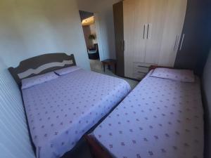 Duas camas num pequeno quarto com um quarto em Casa Encanto em São Miguel das Missões