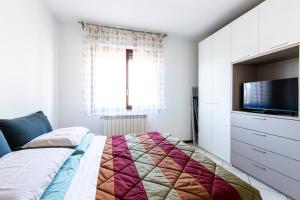a bedroom with a bed and a flat screen tv at Malpensa Express in Vizzola Ticino