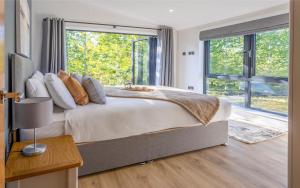 1 dormitorio con cama grande y ventana grande en Keld Spring Lodge Retreat, en Kirkbymoorside