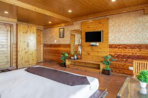 una camera con letto e TV a schermo piatto di KufriVista Mountain Lodge a Kūfrī