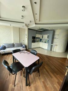 a room with a table and chairs and a couch at Most City Apartments Magnolia in Dnipro