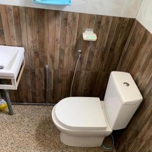 a bathroom with a white toilet and a sink at Chalet Naqib in Gerik +11 photos
