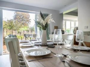 a dining room with a wooden table with plates and glasses at Pass the Keys Grand country home with space for all the family in Exeter