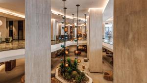 a lobby of a building with columns and a lobby at AX ODYCY Hotel in St Paul's Bay