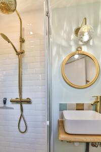 y baño con lavabo y ducha. en Les Voiles - Appart'hotel Le Groix, en Carnac