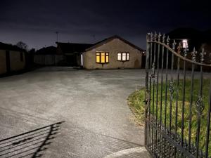 a fence in front of a house at night at High Street Lodge in Clowne