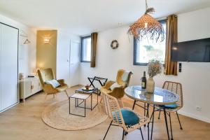 sala de estar con mesa y sillas en Les Voiles - Appart'hotel Le Groix, en Carnac