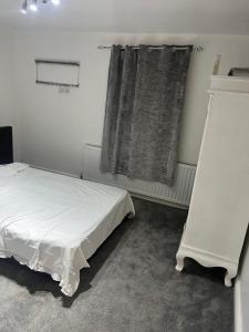 a bedroom with a white bed and a window at High Street Lodge in Clowne