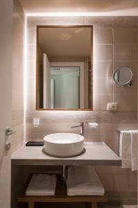 uma casa de banho com um lavatório e um espelho em Mangia's Brucoli, Sicily, Autograph Collection em Brucoli