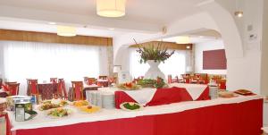 un restaurant avec une table et des assiettes de nourriture dans l'établissement IL RIFUGIO DELLO SCIATORE/HOTEL PARADISO, à Roccaraso