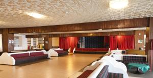 a large room with couches and red curtains at IL RIFUGIO DELLO SCIATORE/HOTEL PARADISO in Roccaraso