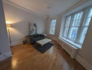 uma sala de estar com um sofá e uma mesa em Star London Warwick Mansions 3-Bed Oasis em Londres