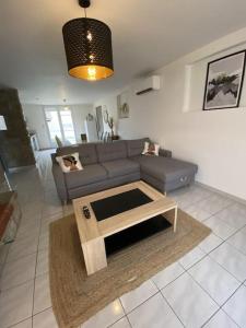 ein Wohnzimmer mit einem Sofa und einem Couchtisch in der Unterkunft Appartement tout équipé 2 chambres + jardin in Saix