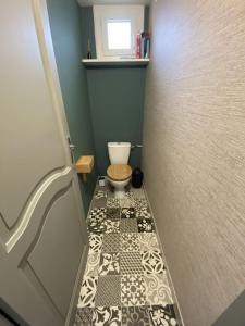 a small bathroom with a toilet and a tiled floor at Appartement tout équipé 2 chambres + jardin in Saix