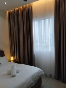 a bedroom with a bed and a large window at Amber Cove Chillax Homestay Melaka in Melaka