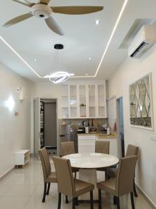 a dining room and kitchen with a table and chairs at Amber Cove Chillax Homestay Melaka in Melaka