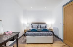 a bedroom with a bed and a desk with two lamps at Cornerstone Cottage in Laurencekirk