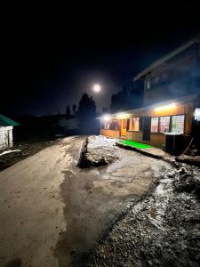 a dirt road in front of a building at night at Gulmarg View Cottage in Gulmarg