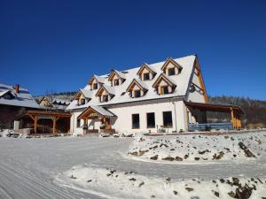 a large white house with a snow covered roof at Miodówka in Stronie Śląskie