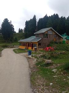 a small building next to a dirt road at Gulmarg View Cottage in Gulmarg