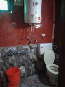 a bathroom with a toilet and a water tank at Gulmarg View Cottage in Gulmarg
