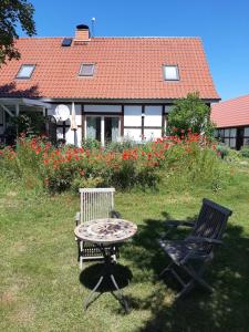 einen Tisch und zwei Stühle in einem Hof mit einem Haus in der Unterkunft Ferienwohnung auf dem Honighof in Krassow