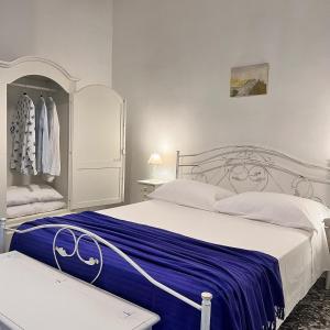 um quarto com uma cama grande e um cobertor azul em Le Casette nel Borgo em Borgagne