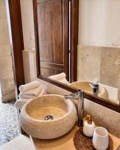 uma casa de banho com um lavatório de pedra e um espelho. em Le Casette nel Borgo em Borgagne