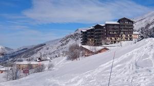 budynek na szczycie pokrytej śniegiem góry w obiekcie Menuires, Beau duplex 8 personnes, Ski aux pieds w Les Menuires