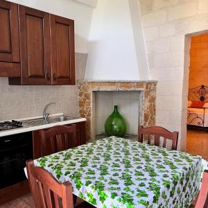 uma cozinha com uma mesa com um vaso verde em Le Casette nel Borgo em Borgagne