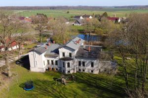 een luchtzicht op een groot wit huis op een veld bij Gutshaus Bartelshagen 