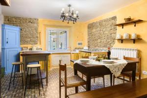 kuchnia ze stołem i krzesłami oraz kamienną ścianą w obiekcie Suite il Corno w mieście Vidiciatico