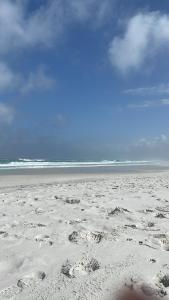 a sandy beach with footprints in the sand at Le Bon Vivant - Praia Grande - Arraial do Cabo in Arraial do Cabo