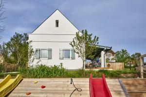 a house with a triangular roof with a playground at Patakporta in Ábrahámhegy