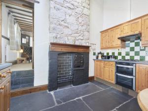 a kitchen with a stove and a stone wall at 1 Bed in Eskdale SZ471 in Beckfoot