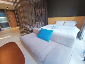 a bedroom with two beds and a couch at Pines Studio Melaka Private Suites in Melaka +17 photos
