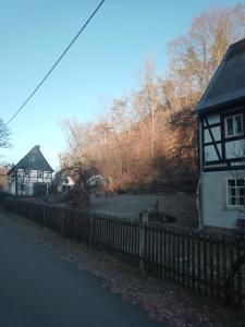 una cerca frente a una casa con un patio en Ruhig und spartanisch Wohnen im Denkmal, en Lichtenwalde
