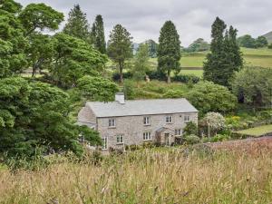 an old stone house in a field with trees at 4 Bed in Sedbergh SZ595 in Milnthorpe